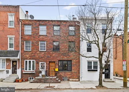 a front view of a building with large tree