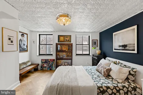 a bedroom with a bed and painting on the wall