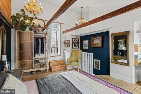 a bedroom with a bed a chair and glass walk in closet