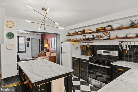 a kitchen with a stove a refrigerator and a dining table