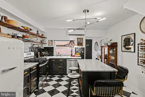 a kitchen with stainless steel appliances a stove a sink dishwasher a dining table and chairs with wooden floor