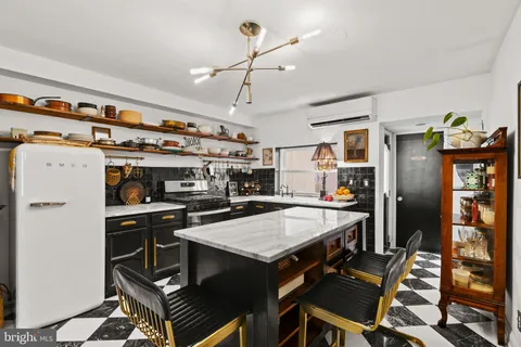 a kitchen with a stove a refrigerator and a dining table