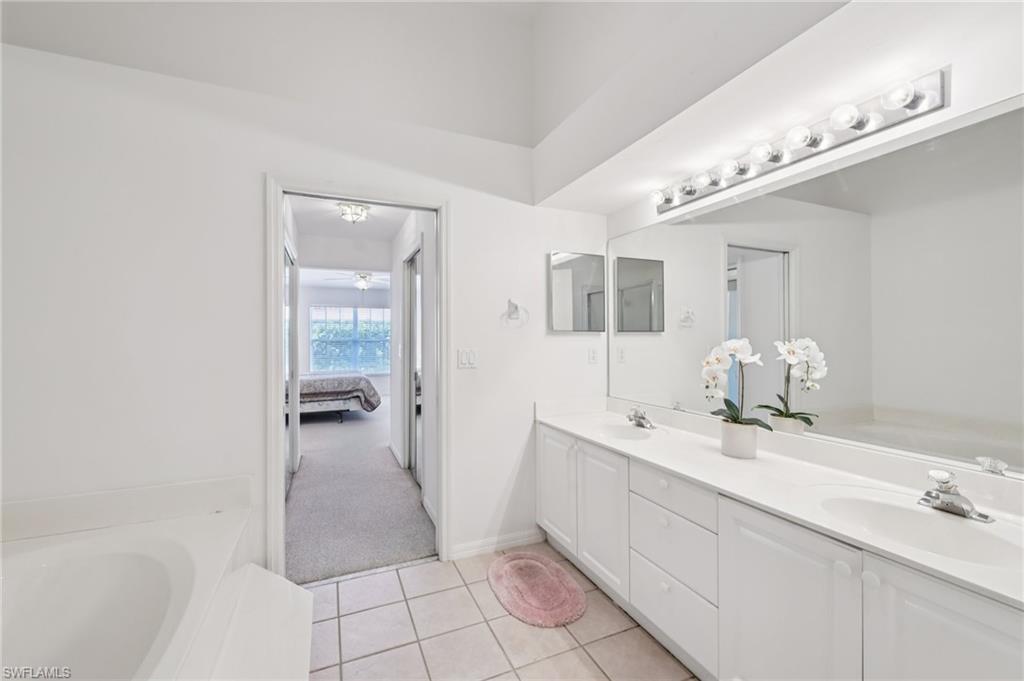387 Melrose Place Naples, FL 34104 - Photo 13 of 26 a spacious bathroom with a double vanity sink a mirror and a bathtub