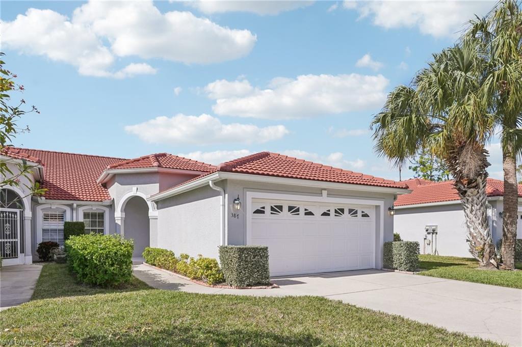 387 Melrose Place Naples, FL 34104 - Photo 2 of 26 a front view of a house with a yard