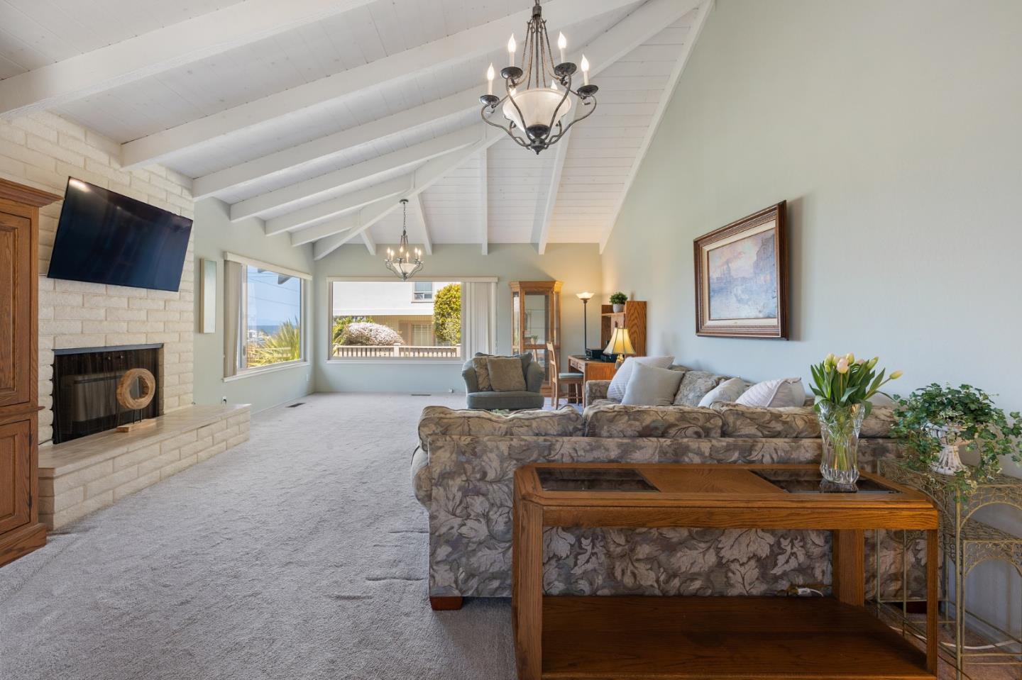 1244 Surf Avenue Pacific Grove, CA 93950 - Photo 7 of 43 a living room with furniture a fireplace and a chandelier