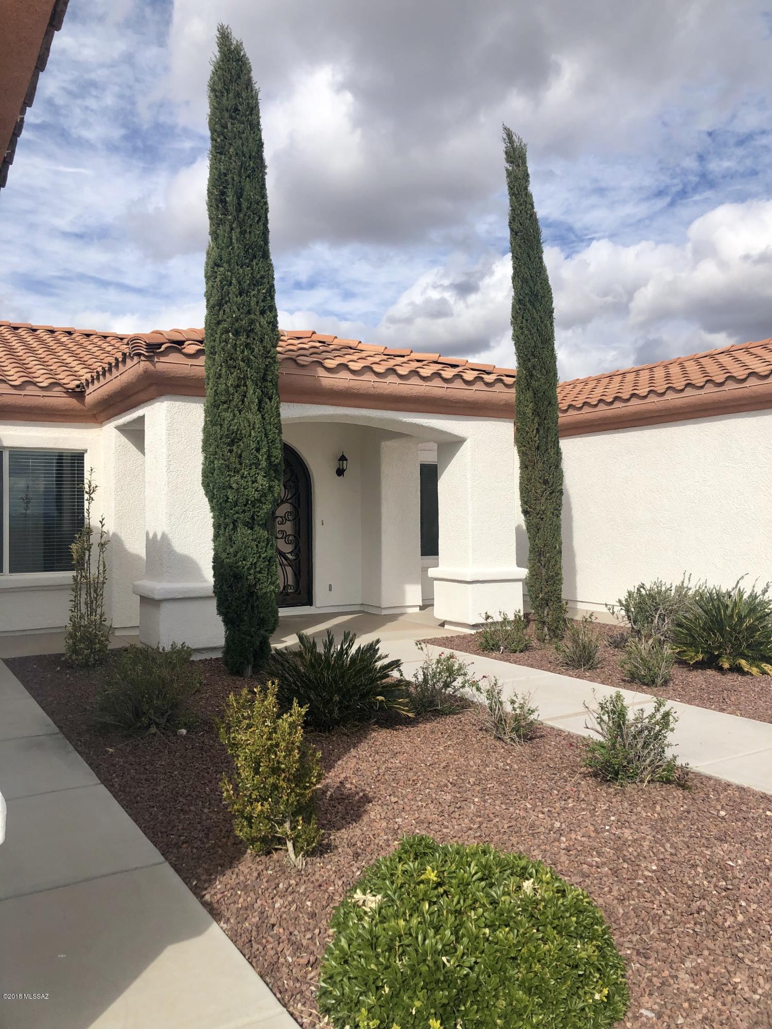 1435 Circulo Sombrero Rio Rico, AZ 85648 - Photo 3 of 40 a front view of a house with a garden and trees