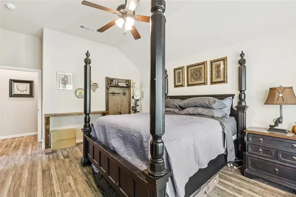 a bedroom with a bed and wooden floor