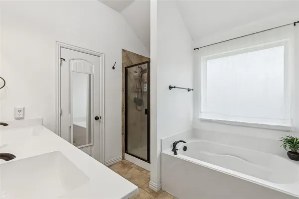 a bathroom with a tub a sink and a window