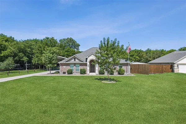 a front view of a house with a yard and trees