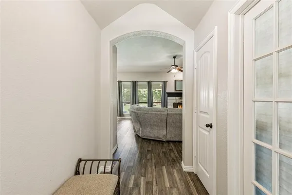 a view of a hallway with wooden floor and a bathroom