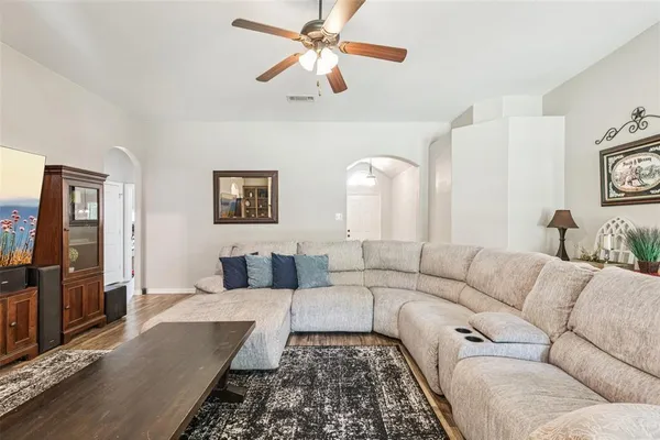 a living room with furniture ceiling fan and a rug