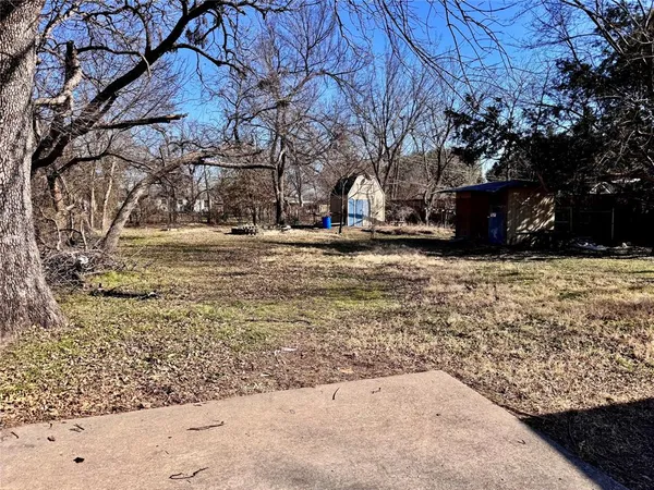a view of a yard with wooden fence