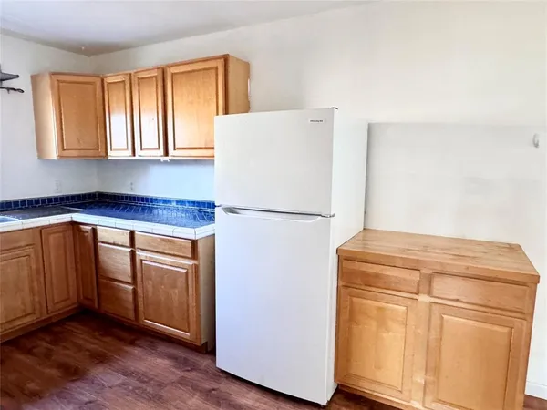 a kitchen with granite countertop cabinets and refrigerator