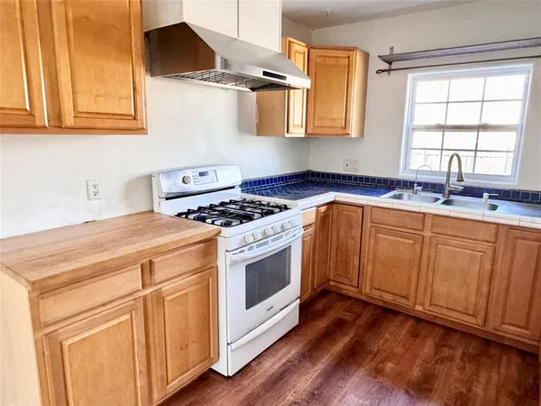 a kitchen with cabinets appliances a sink and a window