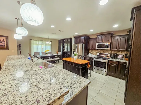 a kitchen with stainless steel appliances kitchen island granite countertop a sink and cabinets