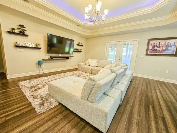 a living room with furniture and a chandelier