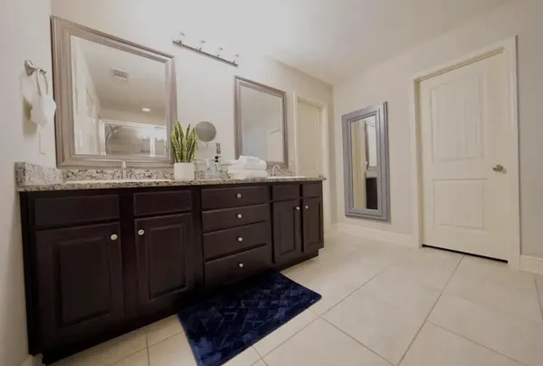 a bathroom with a granite countertop sink double and mirror