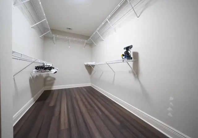 a bed sitting in a spacious bedroom next to a window