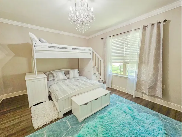 a spacious bedroom with a bed and a chandelier