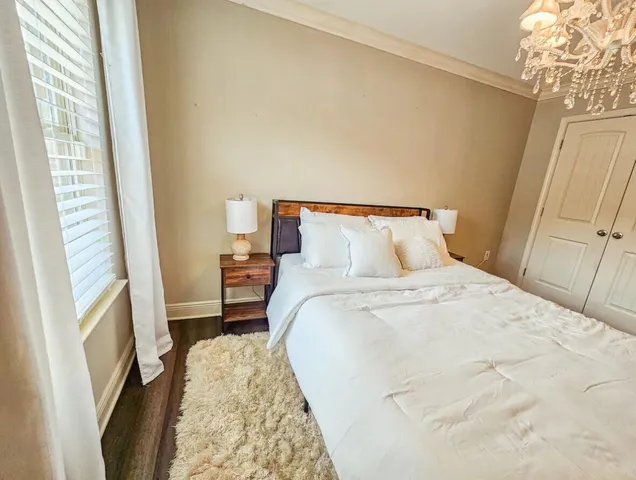 a bedroom with a bed and a chandelier