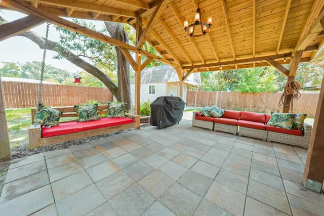 a backyard of a house with barbeque and potted plants
