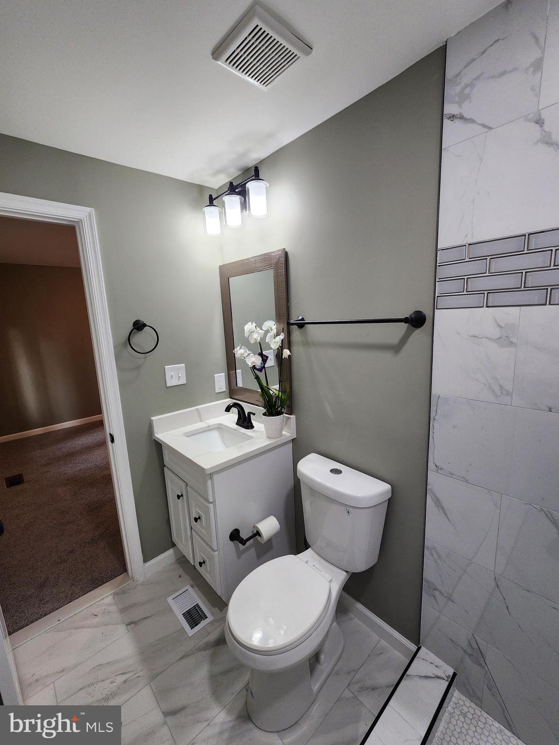 11577 Tomahawk Trail Lusby, MD 20657 - Photo 25 of 28 a bathroom with a toilet sink and mirror