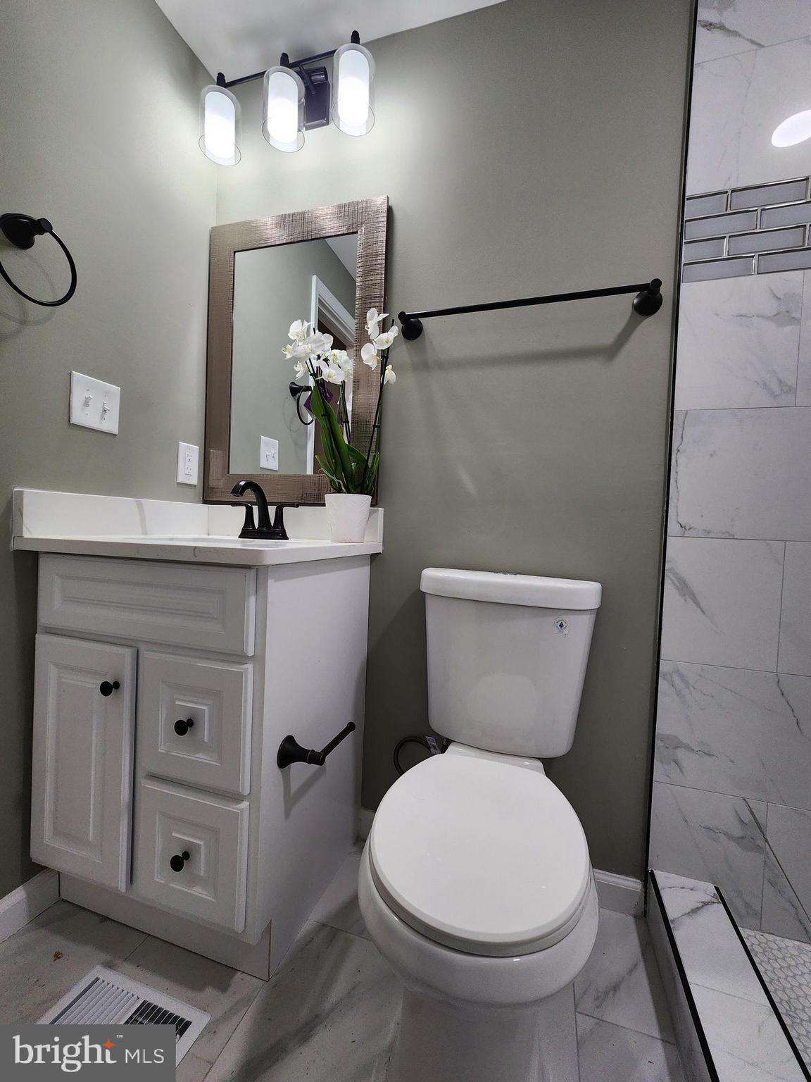 11577 Tomahawk Trail Lusby, MD 20657 - Photo 26 of 28 a bathroom with a toilet sink and mirror