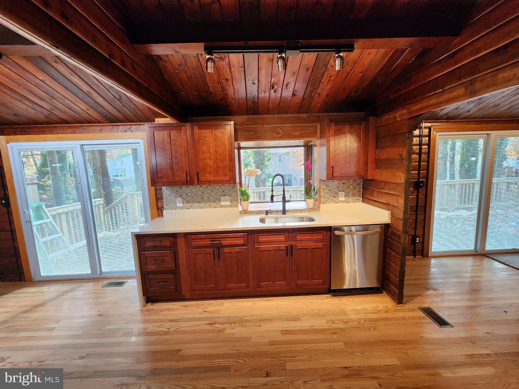 11577 Tomahawk Trail Lusby, MD 20657 - Photo 6 of 28 a large kitchen with stainless steel appliances granite countertop a sink window and wooden floor