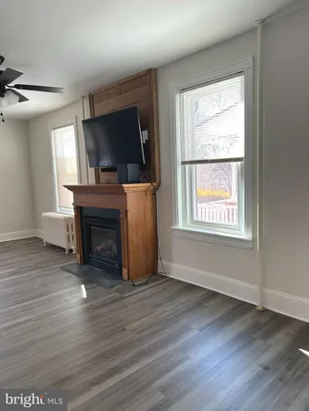 wooden floor fireplace and windows in an empty room