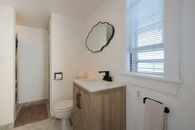 a bathroom with a sink toilet and a mirror