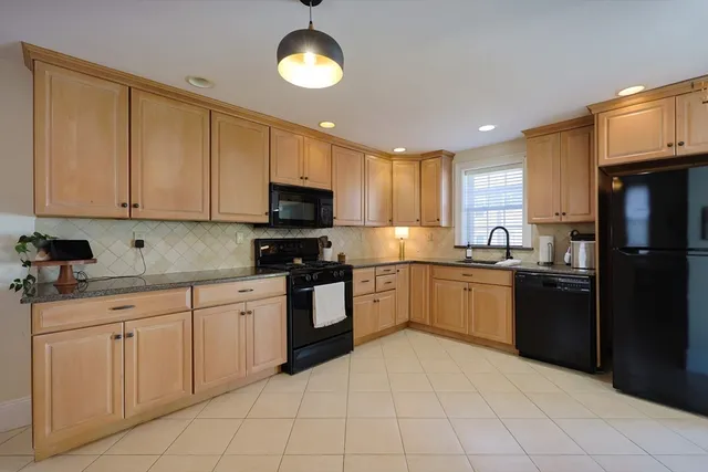 a kitchen with a sink window and stainless steel appliances