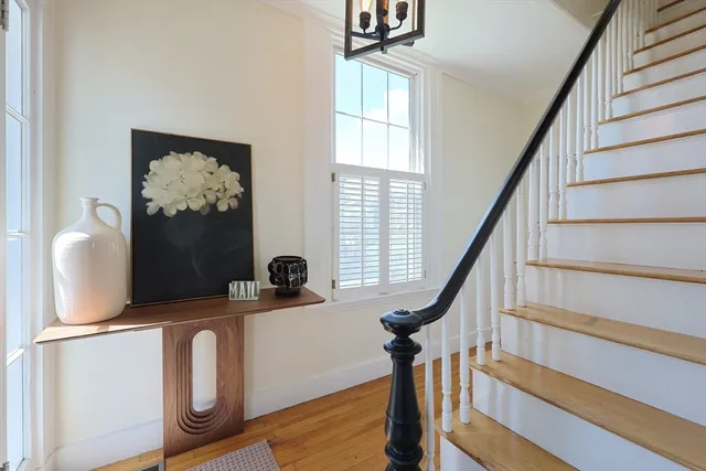 a view of entryway with wooden floor and front door