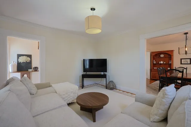 a living room with furniture a rug and a window