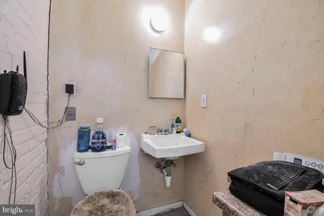 a bathroom with a sink toilet and a mirror