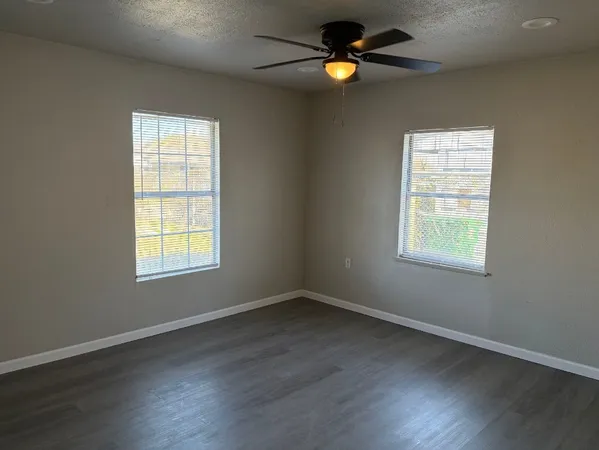 an empty room with a window and wooden floor