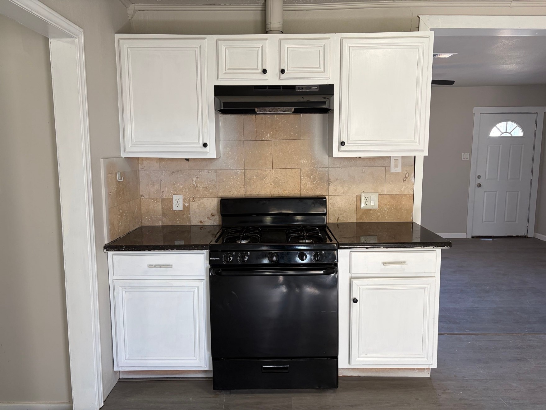 5406 Lyndhurst Drive Houston, TX 77033 - Photo 5 of 17 a kitchen with granite countertop white cabinets and black stove