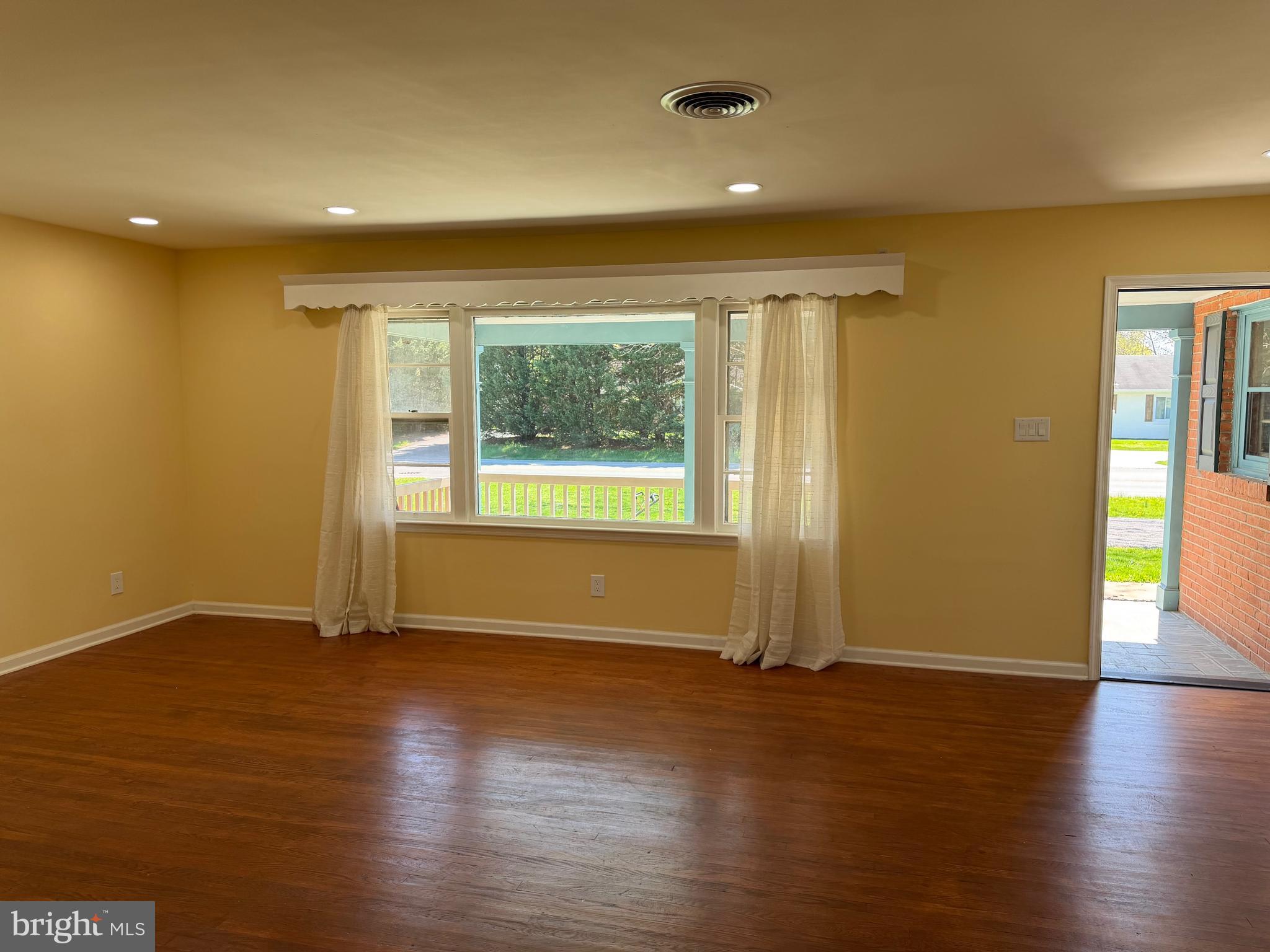 19124 Longmeadow Road Hagerstown, MD 21742 - Photo 7 of 23 an empty room with wooden floor and windows