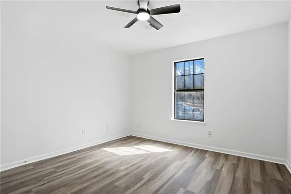 an empty room with a window and ceiling fan