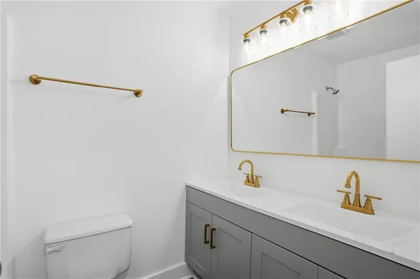 a bathroom with a sink a toilet and mirror