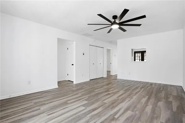 a view of empty room with wooden floor