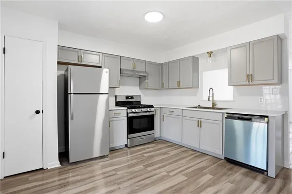 a kitchen with a refrigerator stove and white cabinets