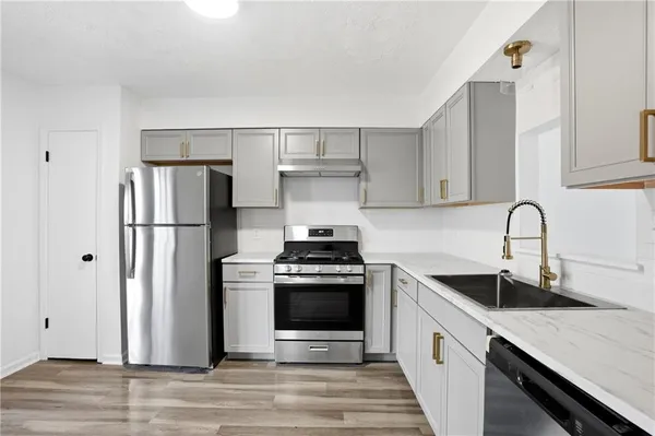 a kitchen with stainless steel appliances granite countertop a sink stove and refrigerator