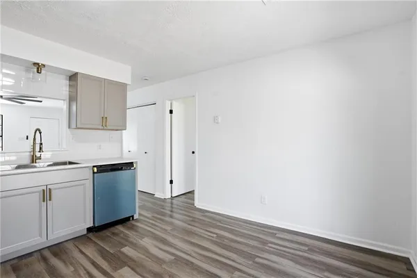 a kitchen with a sink cabinets and wooden floor