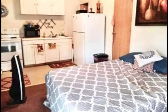 a bedroom with a bed and a view of living room