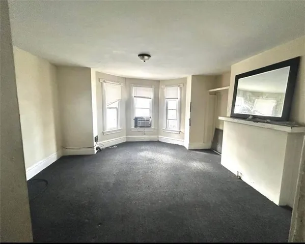 an empty room with windows cabinet and mirror