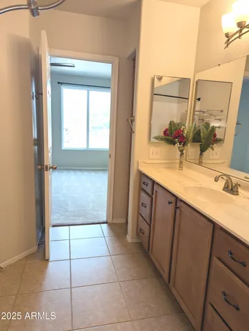 a bathroom with a sink a mirror and next to a window