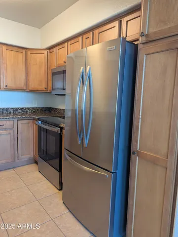 a kitchen with stainless steel appliances granite countertop a refrigerator and a stove top oven