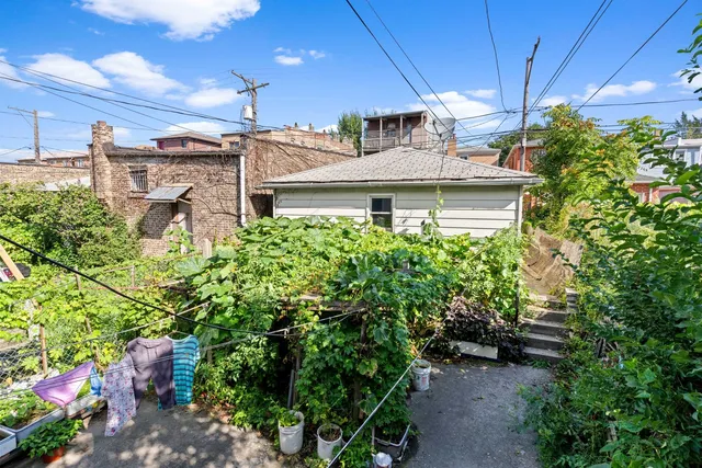 a view of a white house with a big yard and potted plants