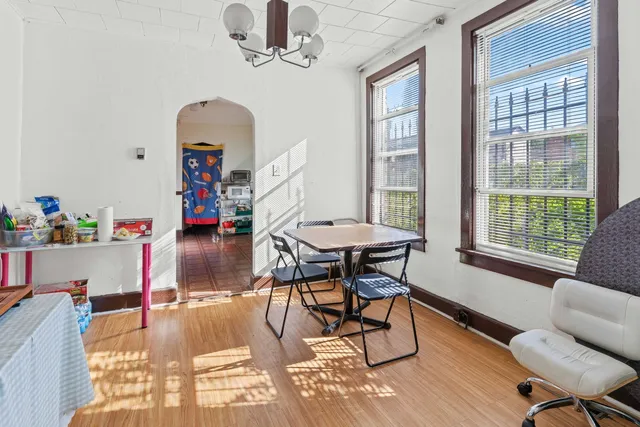 a dining room with furniture a chandelier and wooden floor