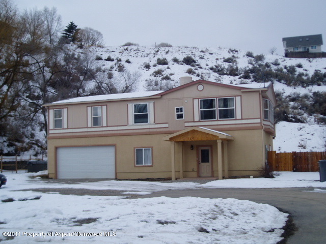 659 Park Avenue Rifle, CO 81650 - Photo 2 of 15 a front view of a house with a yard and garage